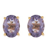 Oval purple sapphire earrings in sterling silver, showcasing brilliance and elegance with gold accents.